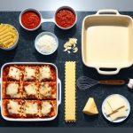 A kitchen counter with ingredients and tools laid out for making lasagna, including pasta, sauce, cheese, and a baking dish